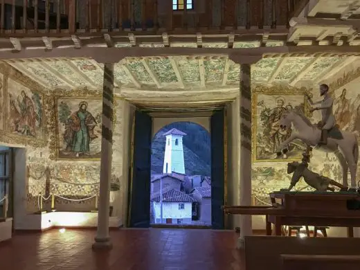 Interior view of the wall paintings and statue of Saint Santiago, patron saint of the church of Kuñotambo with the bell tower - Conservation of Earthen Architecture