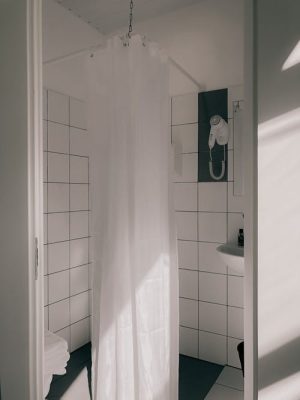 Why does the shower curtain move toward the water?