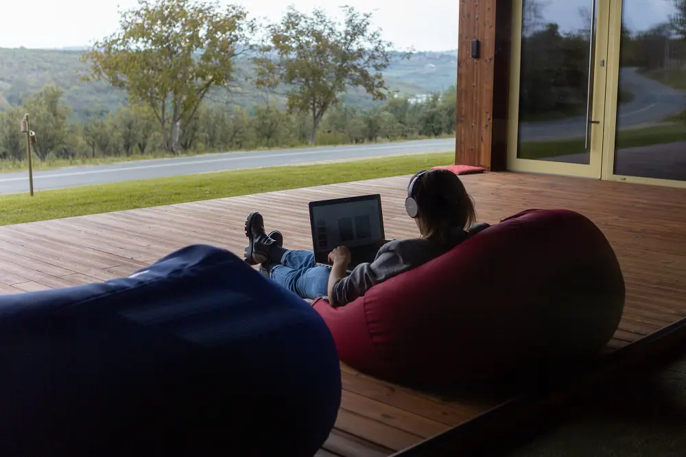 guy with laptop staying the best red bean bag chair on the terrace