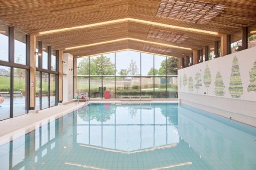 A glass extension that has a swimming pool in it