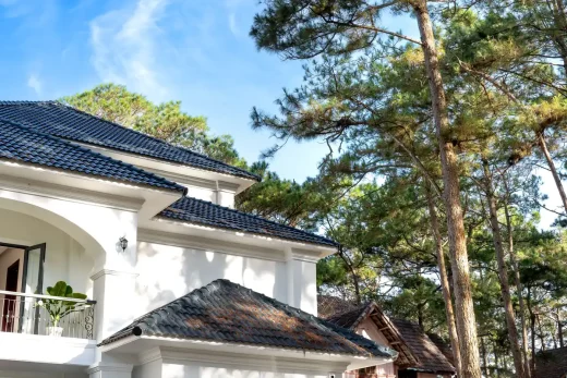 White house with green roof and trees