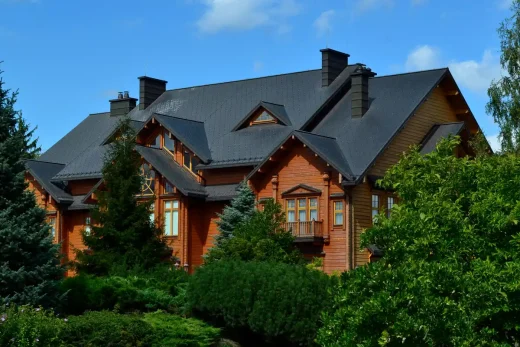 Timber-clad building grey roof dormers with trees